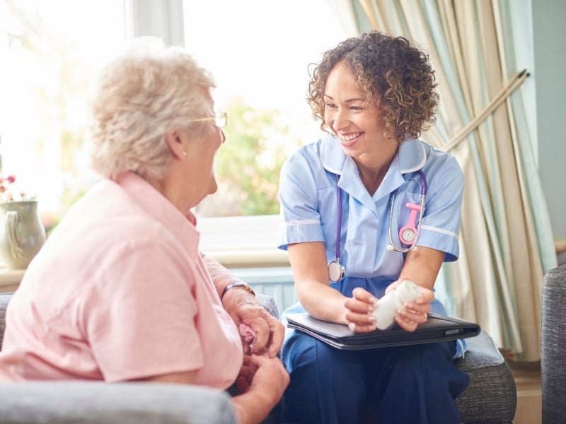 A nurse talking to an elderly woman